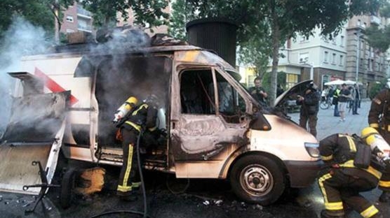 Un grup d'incontrolats cala foc a una unitat mòbil de TV3 que cobria la informació de Can Vies. (Foto: Xavier Gómez)