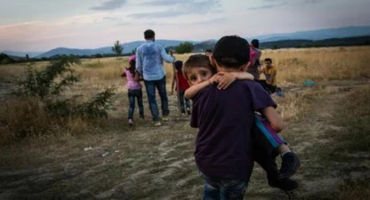 Un jove refugiat porta en braços al seu germà a prop d’Eidomeni (Grècia) | Foto: ACNUR / Andrew McConnell